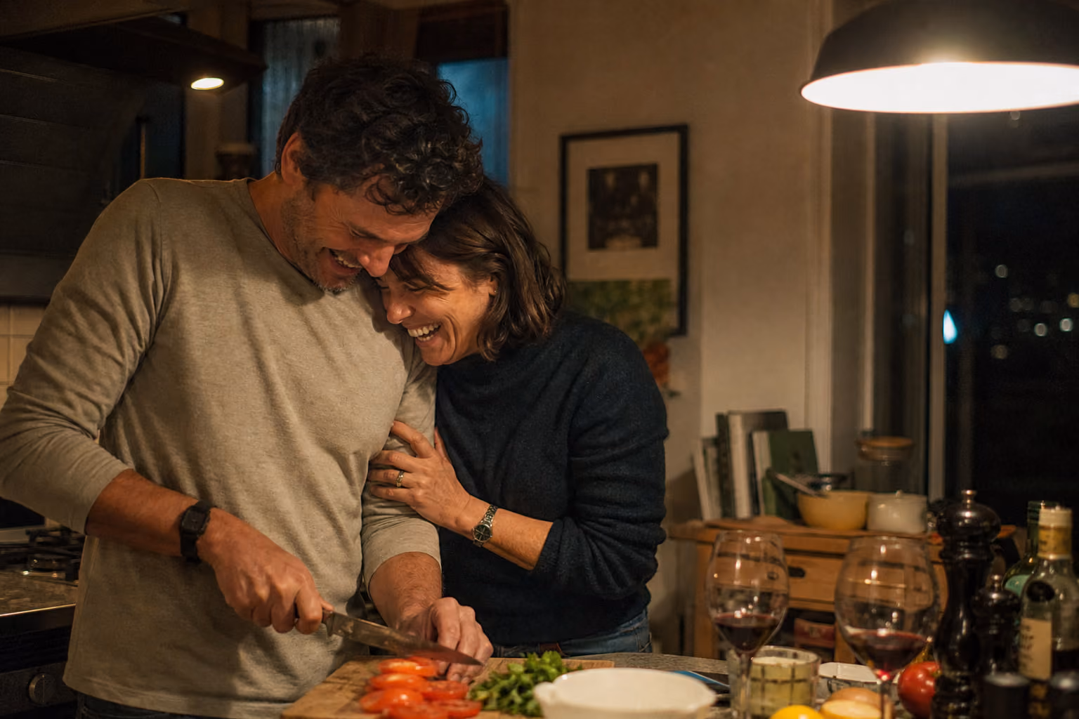 Couple complice préparant le dîner dans une cuisine chaleureuse